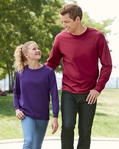 A man and young girl standing together wearing a purple and a  red long sleeve shirt