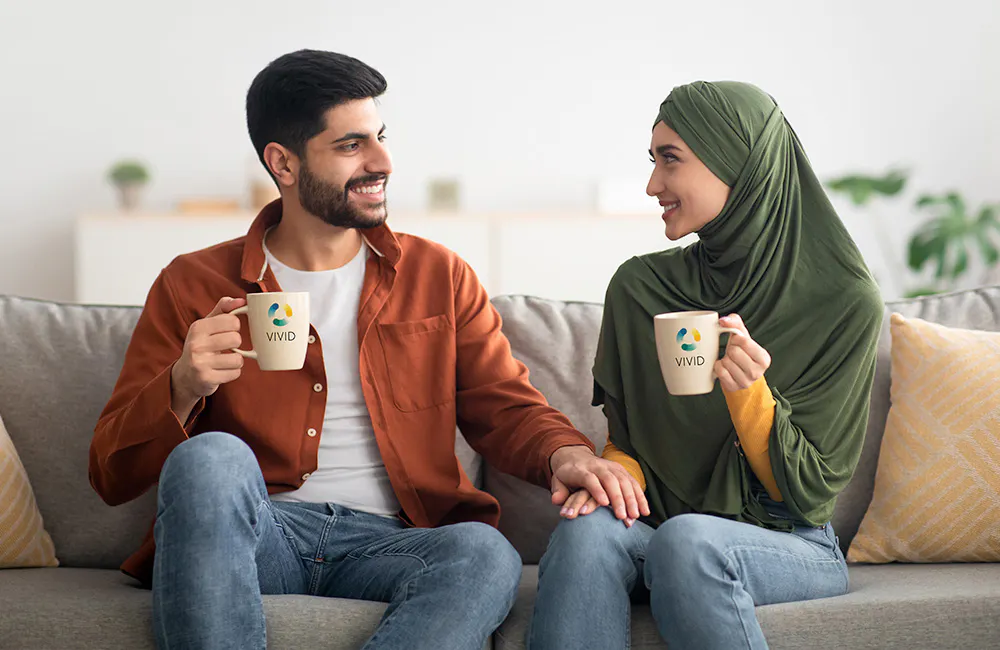 couple drinking from logoed mugs