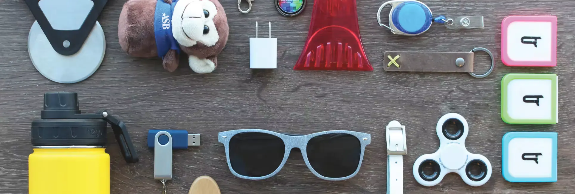 sunglasses, usb drive, water bottle, and other promo products on table