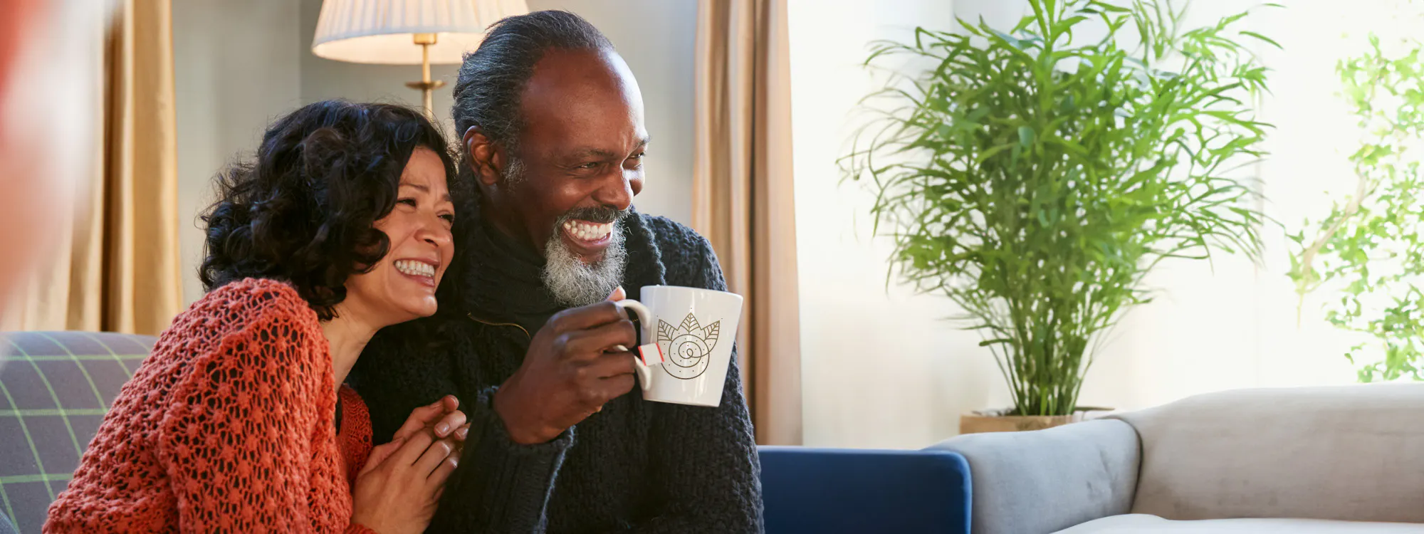 couple laughing holding a coffee mug 