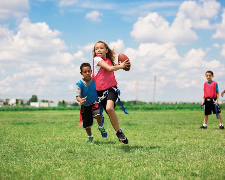 A girl running with a football