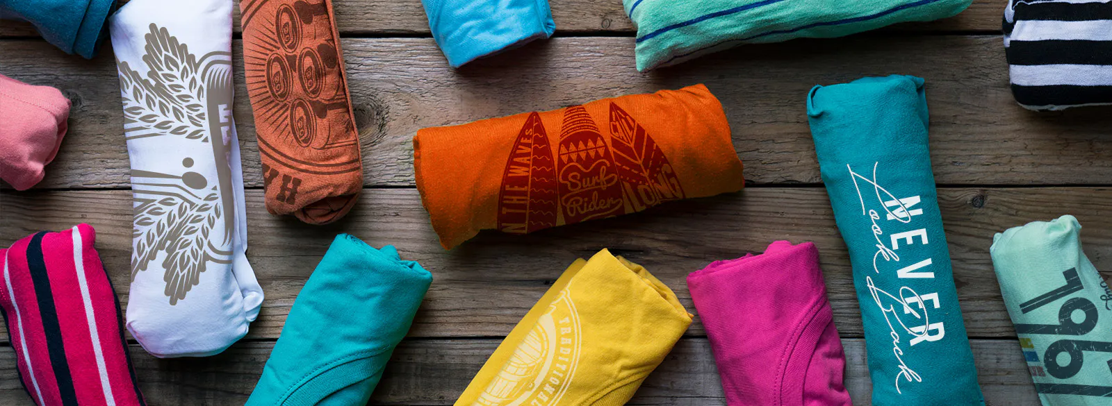 Colorful, rolled tshirts with a variety of imprints 