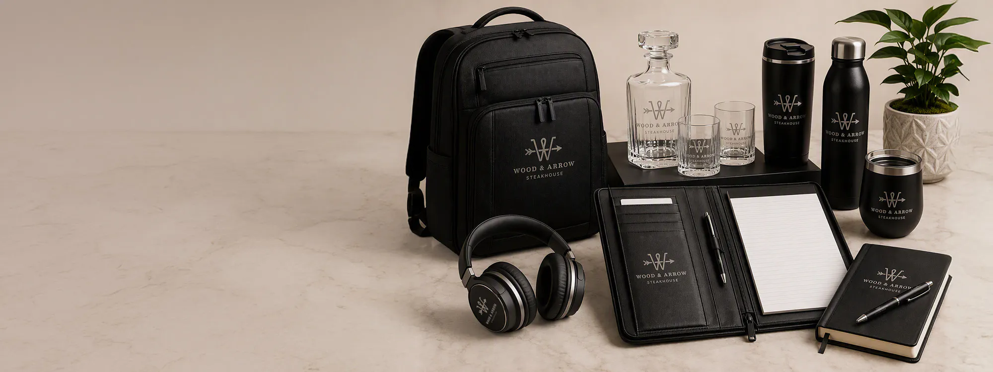 high end promotional products including a backpack, padfolio, headphones, water bottle and barware