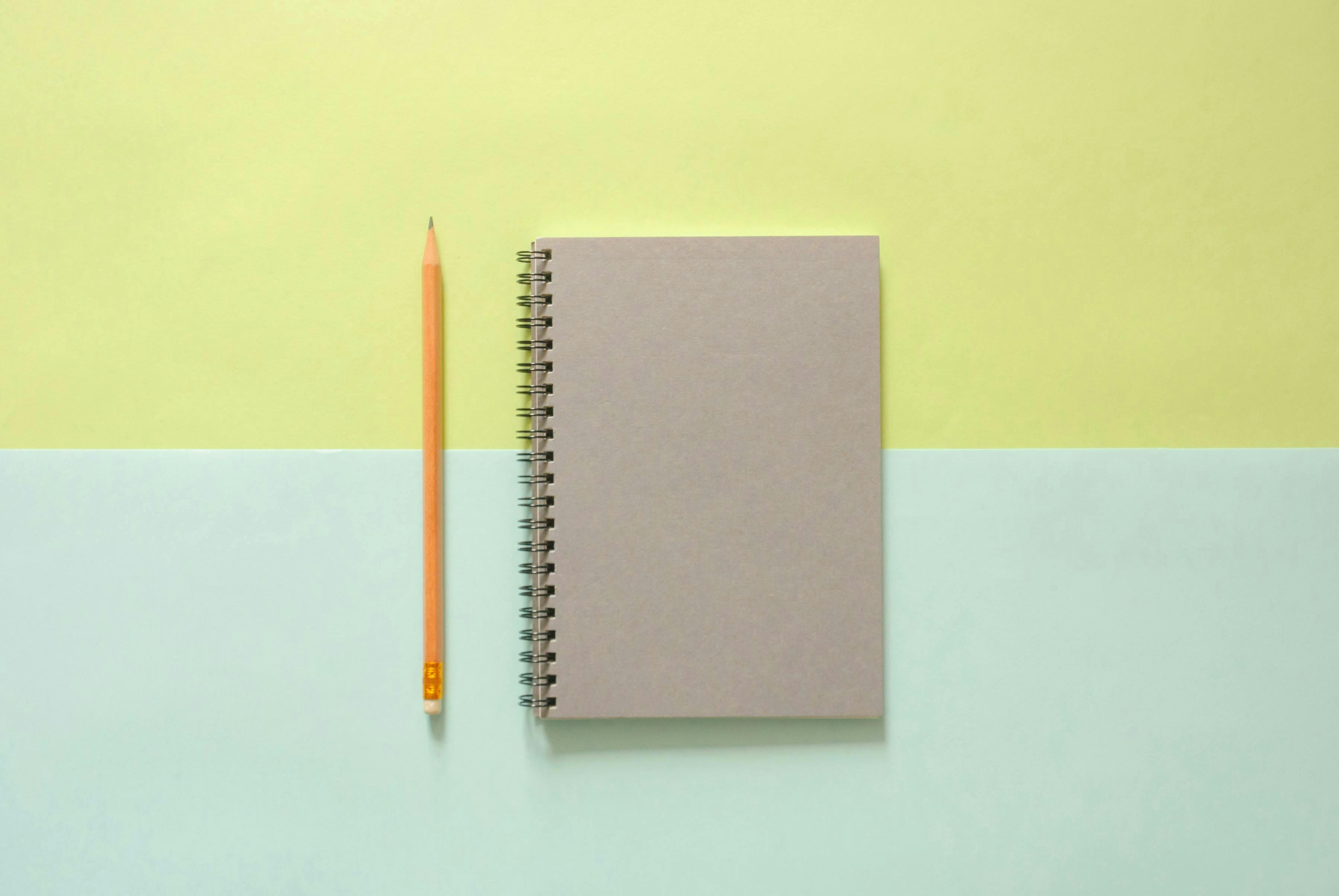 Notebook on multicolor background with pencil laying to left