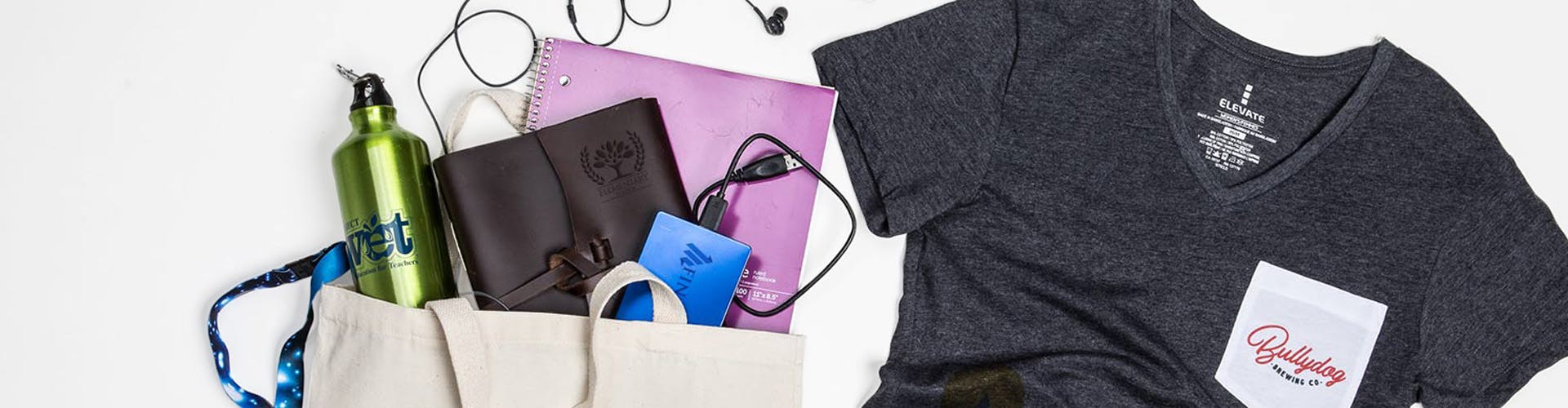 logoed tshirt and other promotional items on a table, shot from above