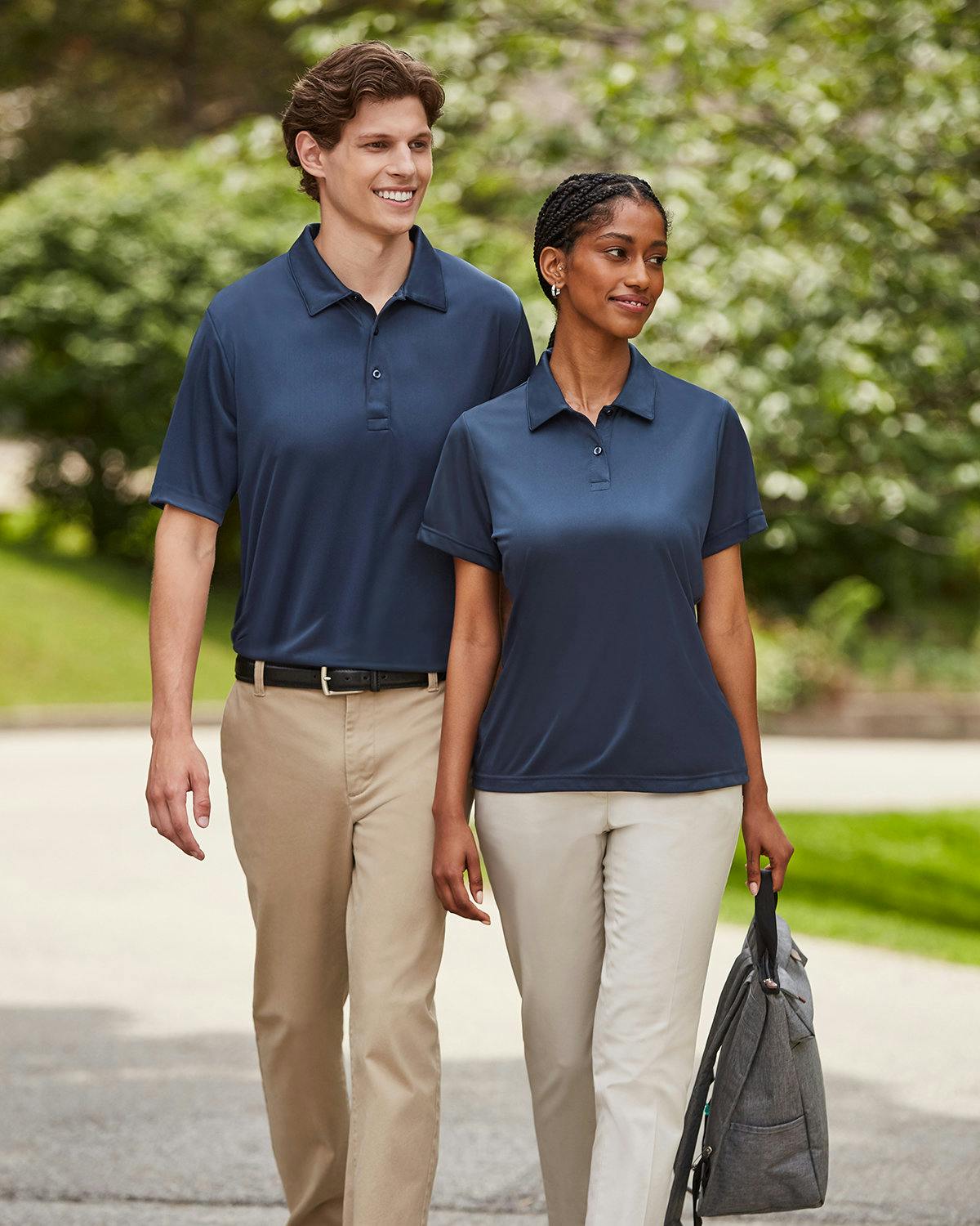 A man and a woman walking together wearing blue polo shirts