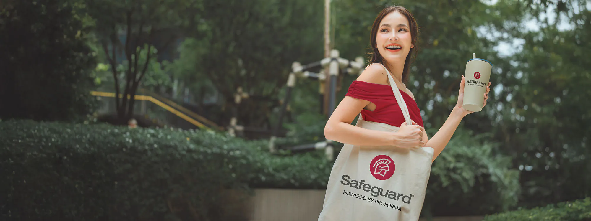 woman holding safeguard branded tote bag and water bottle