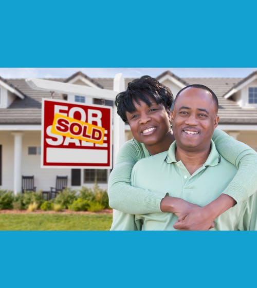 couple hugging in front of for sale sign