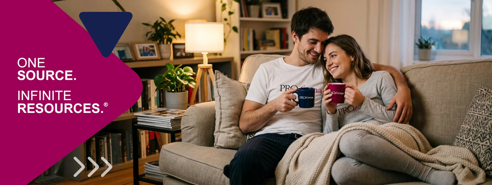 couple sitting on the couch drinking coffee out of Proforma branded mugs