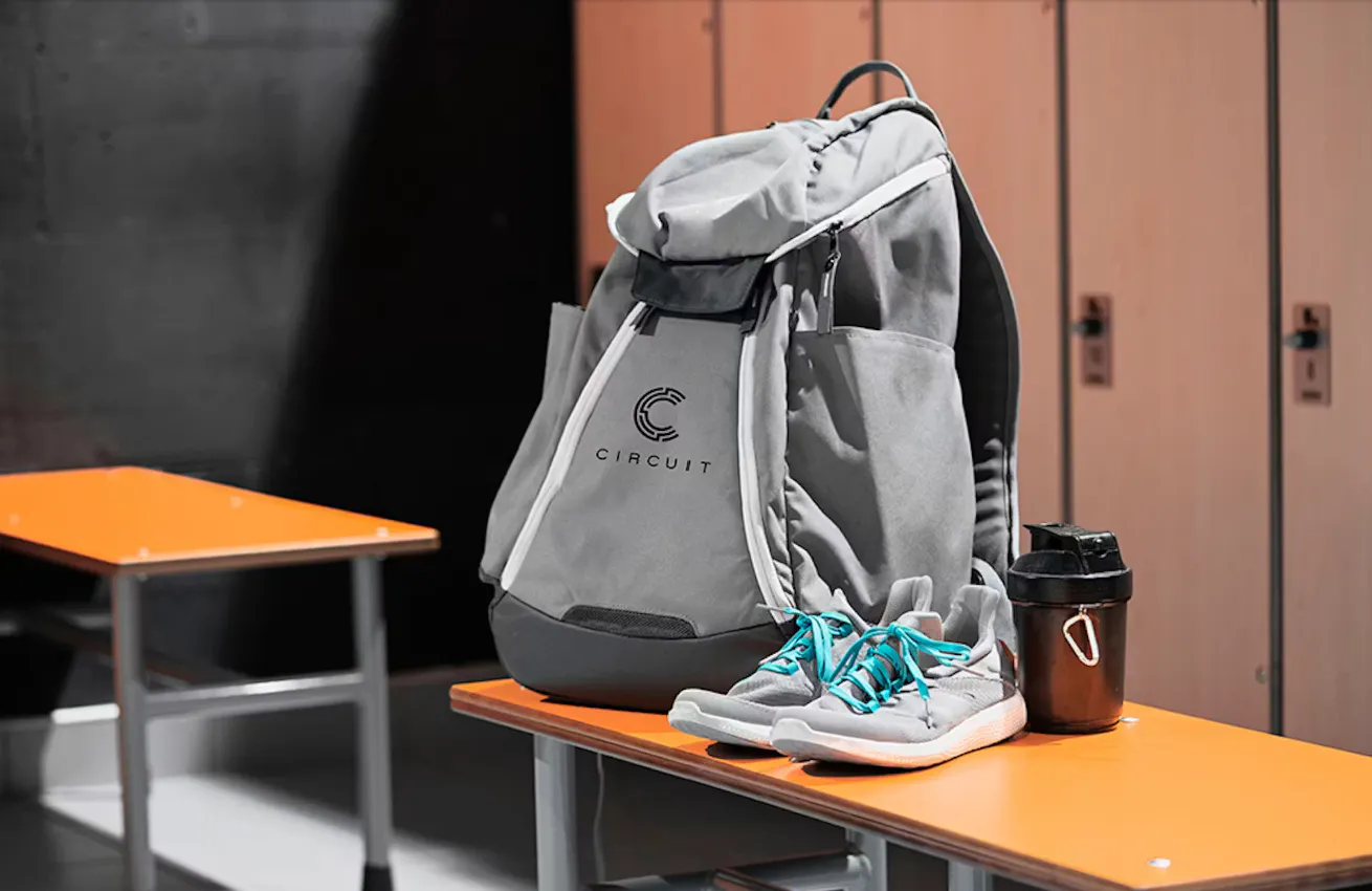 grey backpack on a gym locker room bench