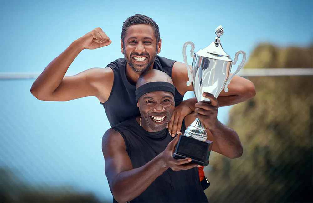 two men holding trophie