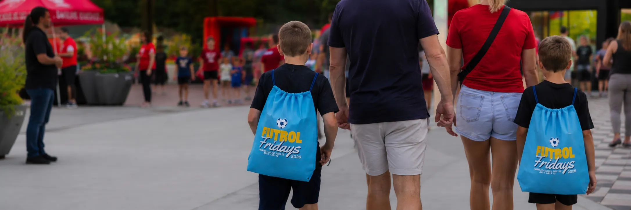 Family walking to Green Street Market with Futbol Friday bags on their back.
