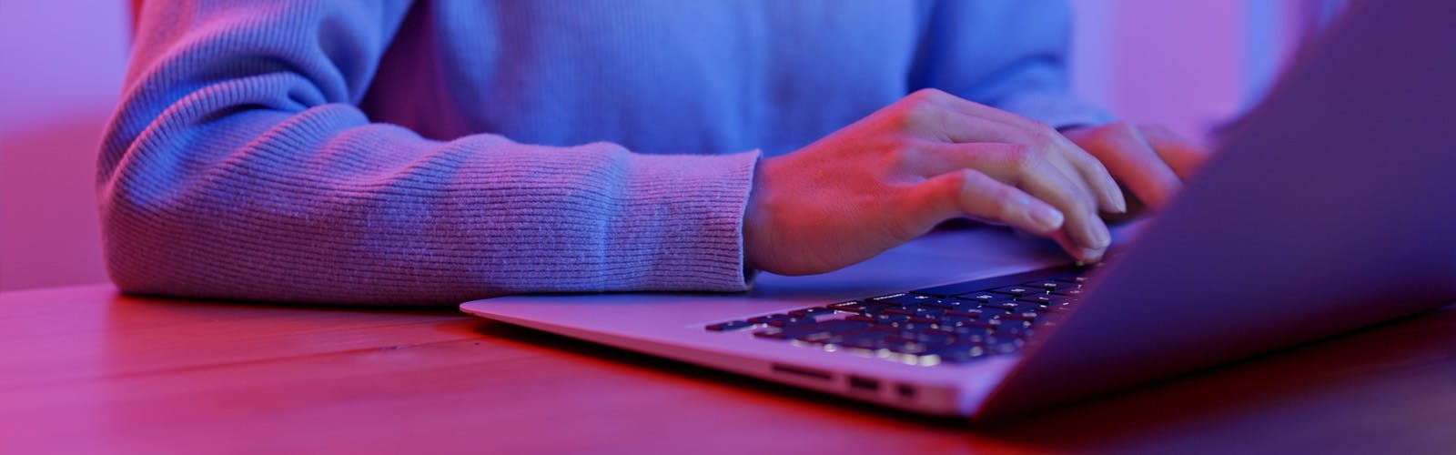 Desk with computer and hands typing