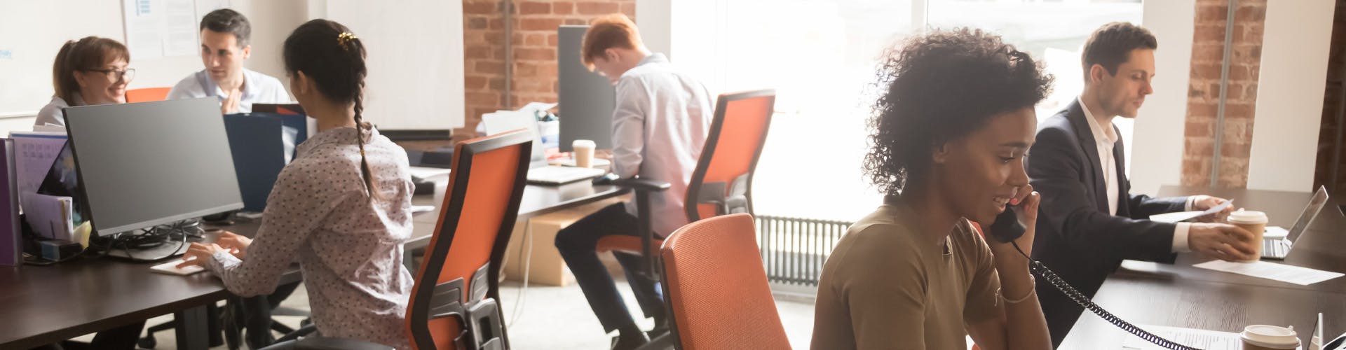 diverse office setting with people working on computers and phones