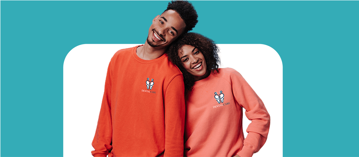 Two people wearing red and coral sweatshirts on a blue and white background