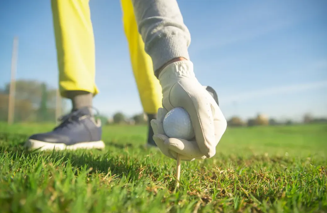 man placing golf  ball