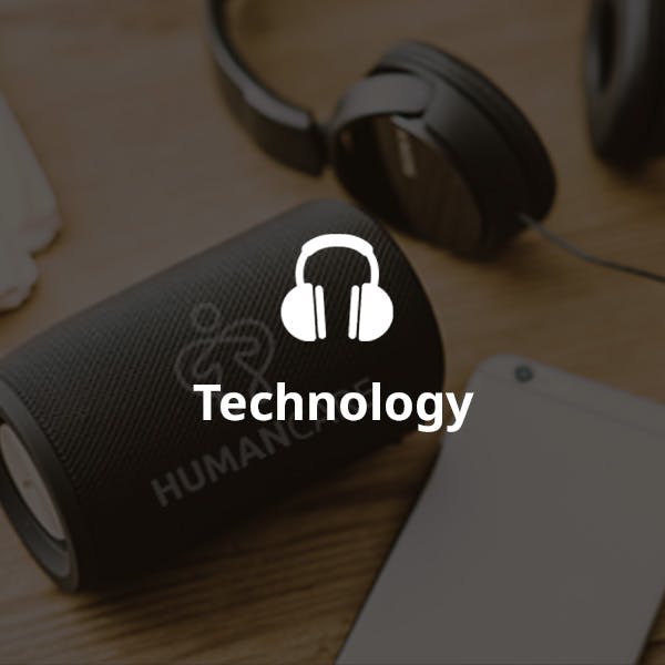 logoed bluetooth speaker and headphones on table