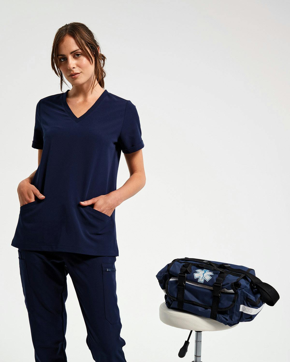 Woman in scrubs with her hands in her pockets 