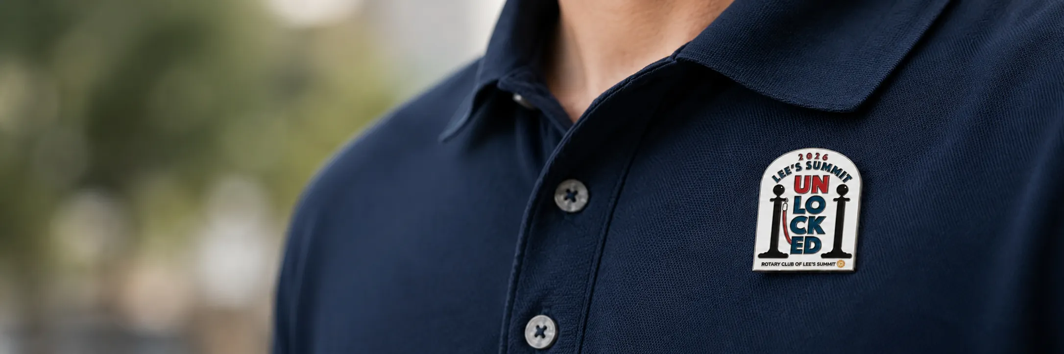 Man wearing a lapel pin on a navy polo