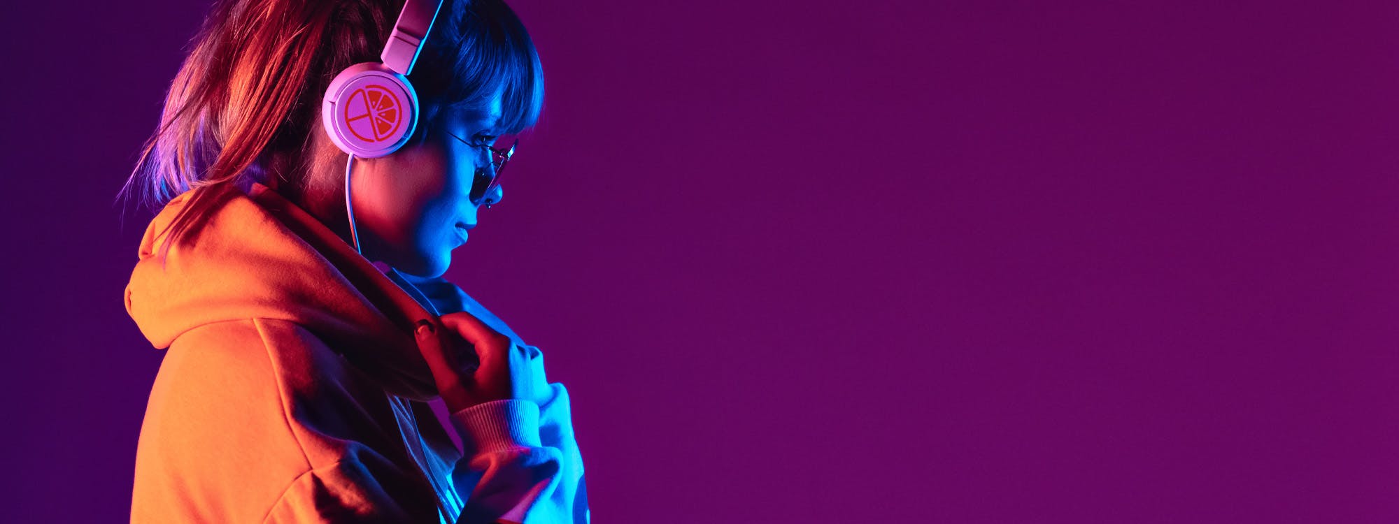woman wearing logoed headlines illuminated in front by a neon glow