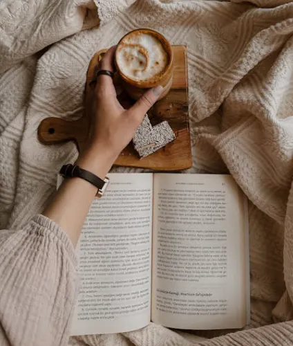 Girl holding coffee and reading book
